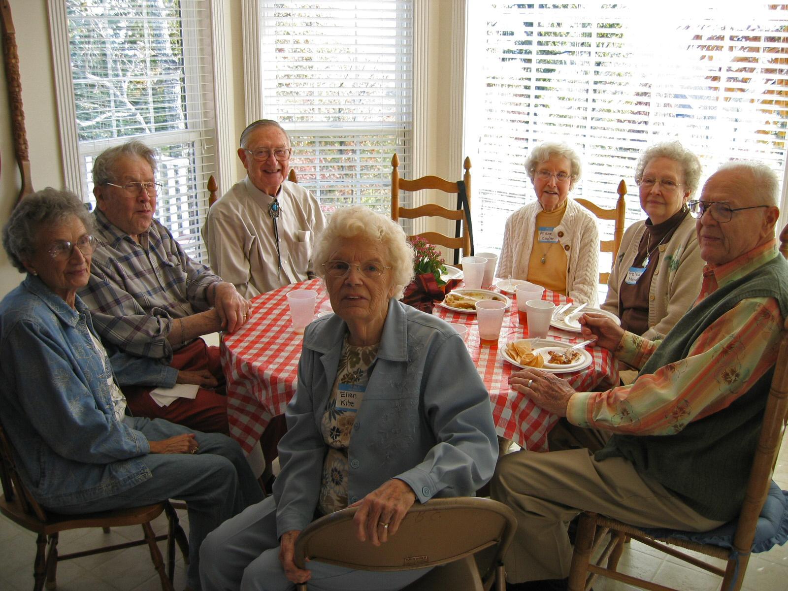 Church members gather around the table for lunch