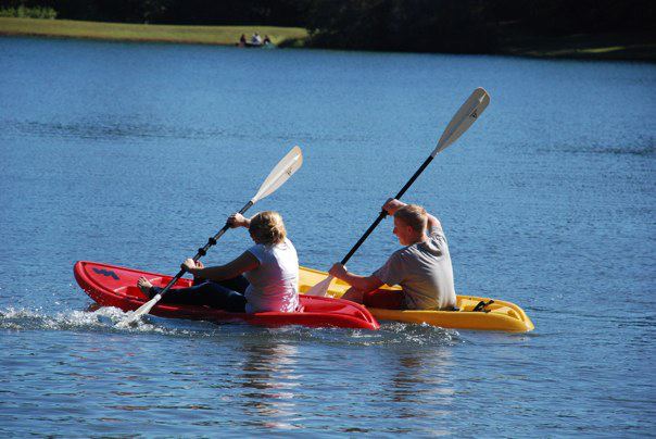 Two students paddling canoes on a lake