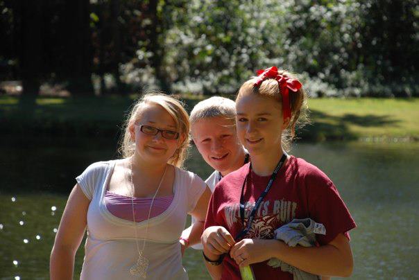 Three students smiling near the lake