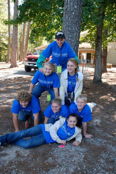 Students on their knees form a tower