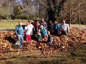 Church members standing in leaves to be raked