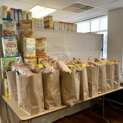 Paper grocery bags filled with bread, cereal, and other staples.