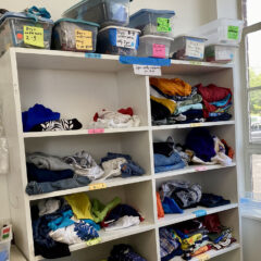 Folded children's clothing on white shelves