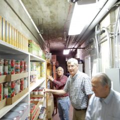 Three men organize pantry shelves