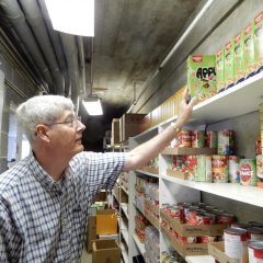 Jim Williamson places food on a pantry shelf