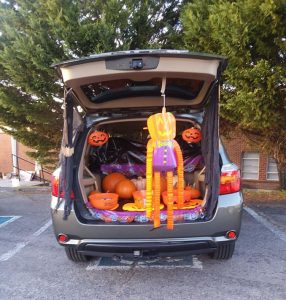 Car hatch open to pumpkins and candy