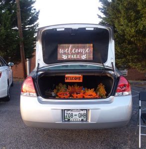 Car with a welcome sign and three orange bowls of candy