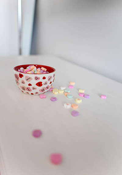 Bowl of candy hearts on a white table