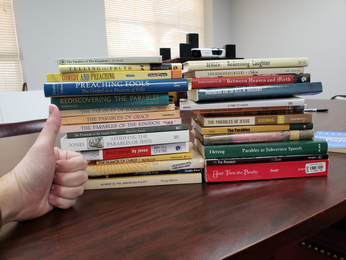 2 stacks of books with a hand for comparison