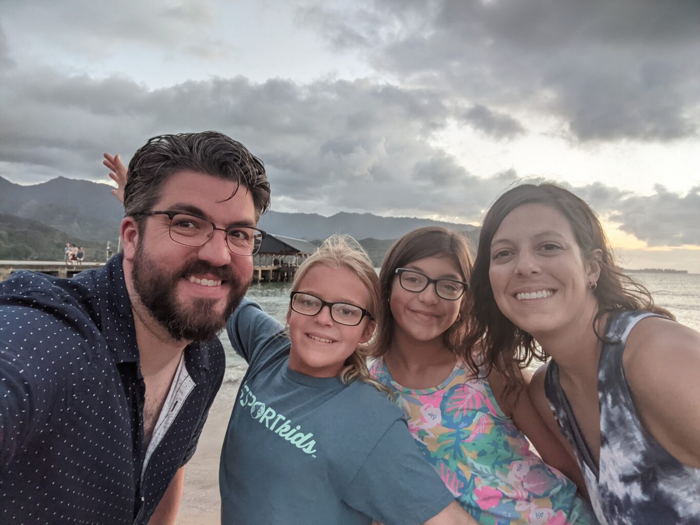 a family posing at sunset over a bay