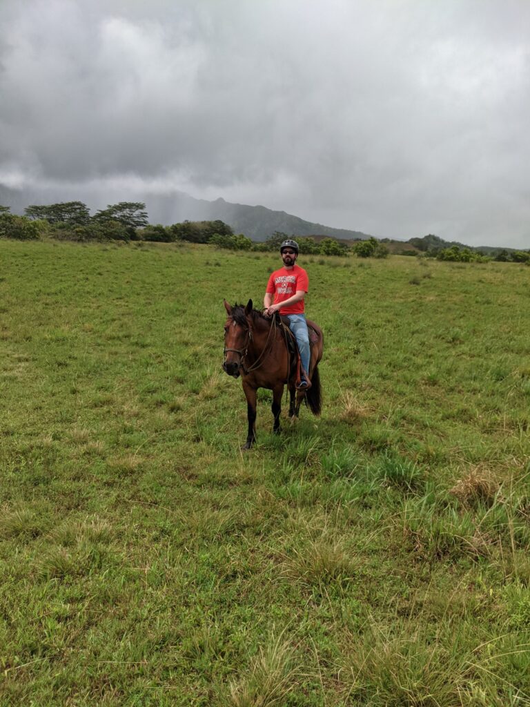 A lage man riding a patient horse