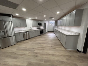 Expansive kitchen with gray cabinets and silver kitchen appliances